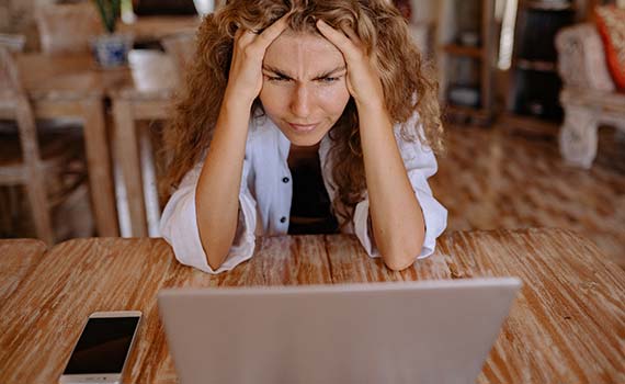 Femme devant son ordinateur cherchant des informations sur un forum de réméré