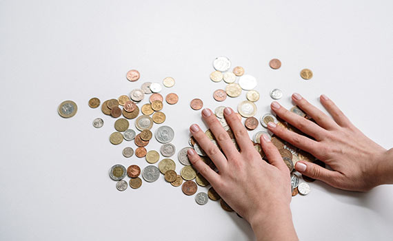 Personne regroupant des pièces de monnaie pour illustrer un rachat de crédits